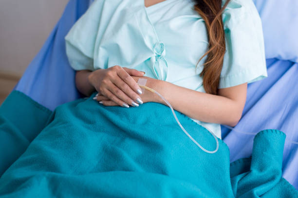 paciente de la mano mujer recibiendo con solución salina y tratamiento en un hospital, de cerca - iv drip chemotherapy drug bag intensive care unit fotografías e imágenes de stock