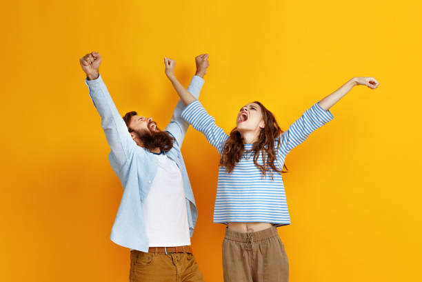 istock young happy couple won emotionally celebrating win on colored yellow background 1091129906