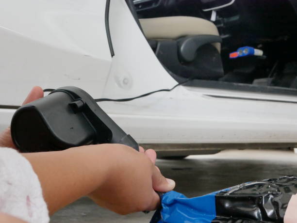 女性の手押し車のプラグに接続されている、小型の空気ポンプを使用してロッキング人形を膨らませる - inflating balloon women growth ストックフォトと画像