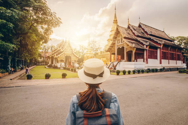 Female tourist looking to the beautiful view of Wat Phra Singh in Chiang Mai, Thailand at sunset. One of the best examples of classic Lanna style architecture in Chiang Mai province of Thailand. chiang mai province stock pictures, royalty-free photos & images