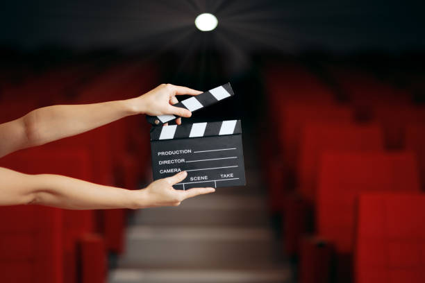 Hands Holding Director Movie Clapper in Cinema Theatre Film slate announcing premiere in movie theatre audition photos stock pictures, royalty-free photos & images