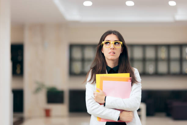 Confused Businesswoman Holding Paperwork in Office Building Funny nervous employee waiting for job interview shy stock pictures, royalty-free photos & images