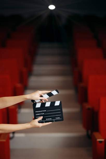 Hands Holding Director Movie Clapper in Cinema Theatre Film slate announcing premiere in movie theatre audition photos stock pictures, royalty-free photos & images