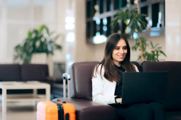 Photo of Woman with Laptop and Luggage in Airport Waiting Room