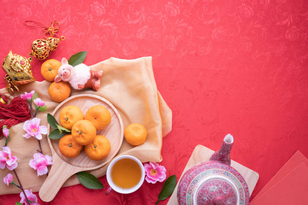 frutas naranja, flor de cerezo rosa y una tetera con espacio de copia de texto sobre fondo de textura rojo, fondo año nuevo chino. - green tea cherry blossom china cup fotografías e imágenes de stock