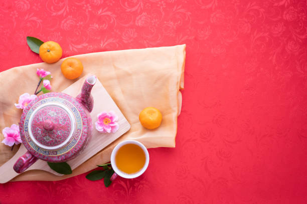 tetera y taza de té con flor de cerezo sobre fondo rojo, concepto de fondo de año nuevo chino. - green tea cherry blossom china cup fotografías e imágenes de stock