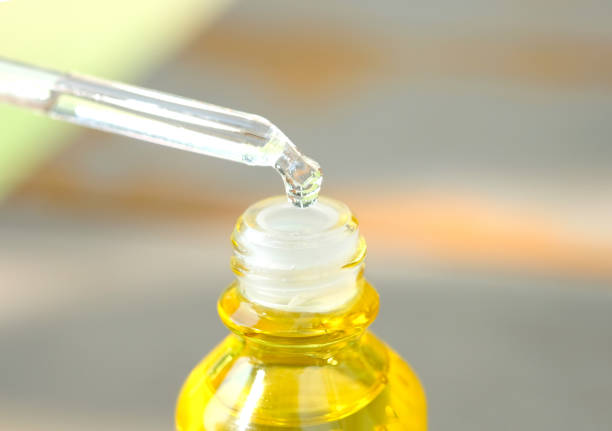 istock Dropping serum collagen moisturizer of face into clear yellow bottle soft light background. Protector skin Treatment facial essence oil, Vitamin C. Beauty and spa Concept. 1091156676