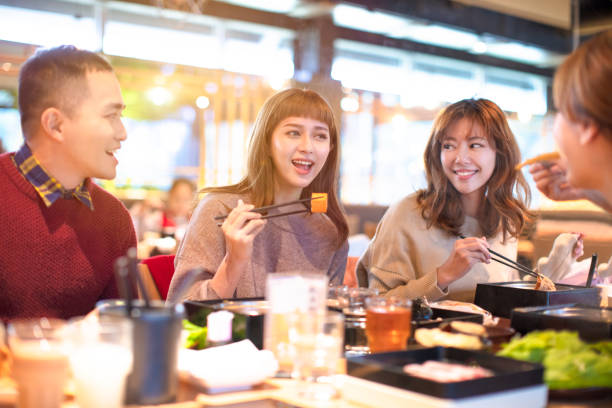 groupe de jeunes asiatique heureux manger dans le restaurant - eating men food chopsticks photos et images de collection