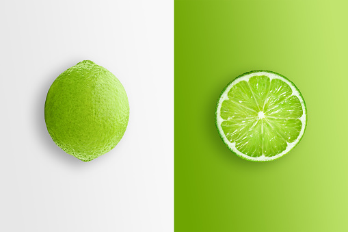 Creative background, lime and lime slices on a white and green background. Flat lay, copy space, layout. The concept of nutrition, fresh fruit, natural products, juice.