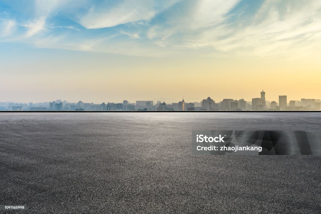 日出時城市天際線和有空曠柏油路的建築 - 免版稅城市圖庫照片 日出時城市天際線和有空曠柏油路的建築 - 免版稅城市圖庫照片