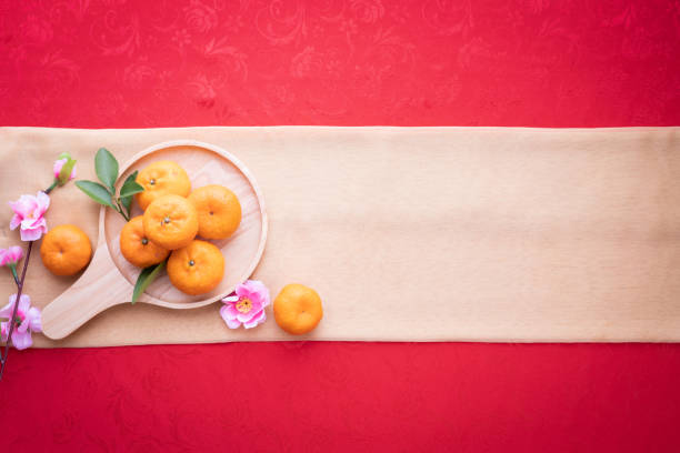Orange fruit, Pink cherry blossom with Copy space for text on red texture background, Chinese new year background. top view.