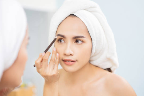 istock Beautiful Woman asian doing Makeup Eyebrow Pencil 1091176044