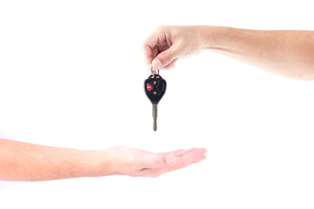 istock Man hand holding car keys exchange isolated on white background 1091178096