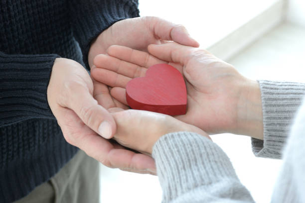 istock Heart object covered by man and woman's hands 1091179820
