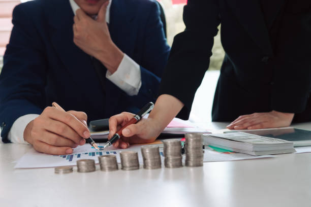 istock asian business people meeting working with pointing graph discussion and analysis data charts and graphs.Business finances and accounting concept,stacks of coins,Saving money concept 1091190220