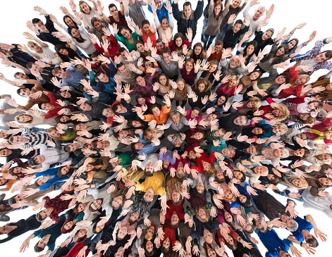 Directly above view of group of happy people standing with their hands raised and looking at the camera. Isolated on white.
