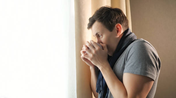 istock Sick man with hot drink near window 1091200926