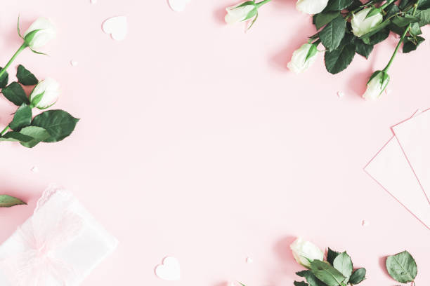 Valentine's Day composition. Gift box, white rose flowers, envelope on pastel pink background. Valentine's day, Mother's day concept. Flat lay, top view, copy space