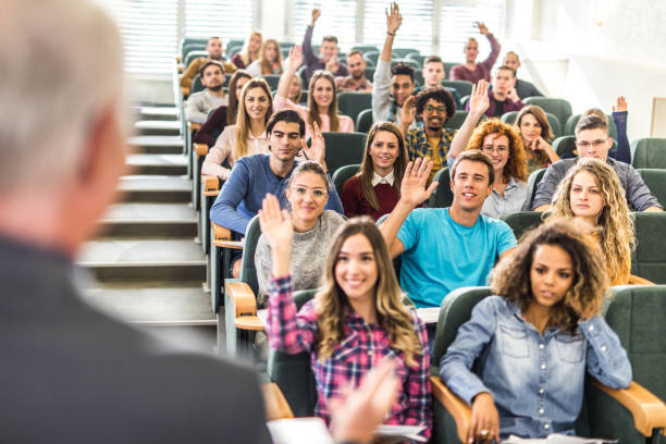 istock Large group of happy college students raising arms on a class. 1091216930