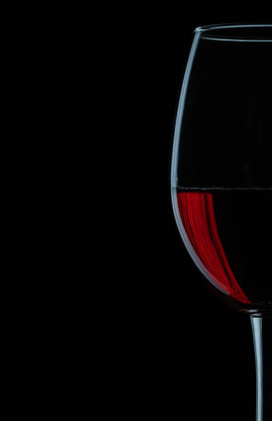 istock very close up view on wineglass with red wine on black background. 1091219836