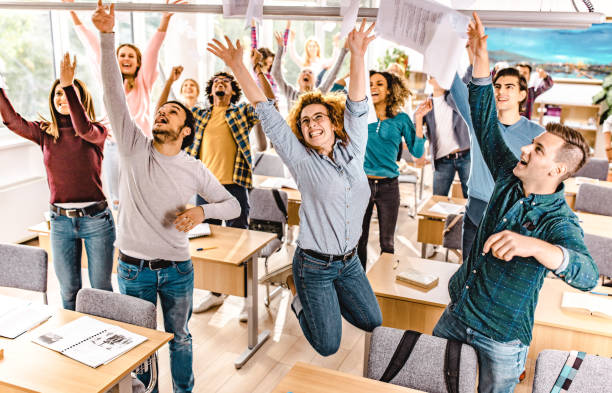 istock Large group of joyful students throwing papers while celebrating the end of a school year. 1091220440