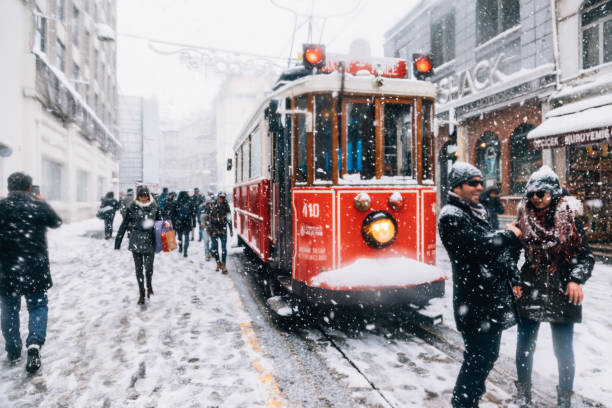 Winter in Istiklal Street, Beyoglu, Istanbul. Istanbul, Turkey - January 8, 2017: Nostalgic Trams passing through Crowded Istiklal street in a snowy winter day in Taksim, Beyoğlu, Istanbul, Turkey. snowing stock pictures, royalty-free photos & images