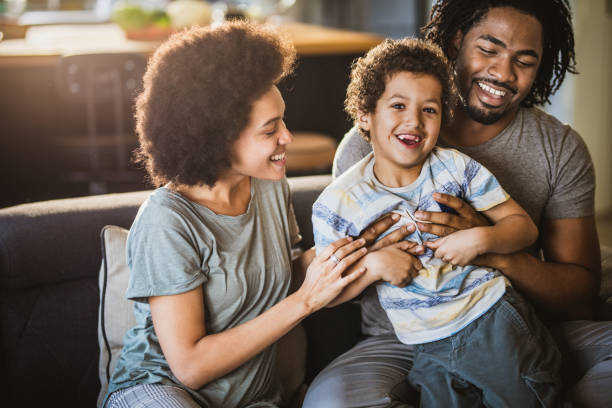 istock Young cheerful black parents having fun with their small son at home. 1091224254