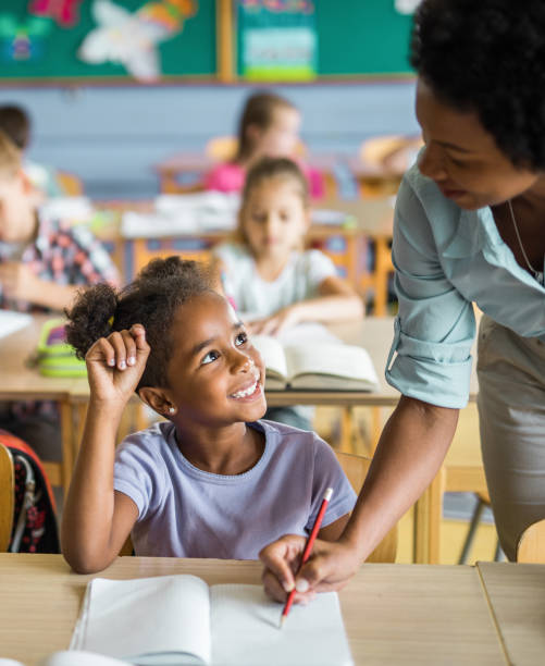istock Happy black girl talking to her teacher during a class at elementary school. 1091227144