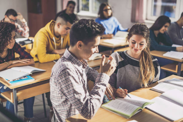 istock Smiling high school friends cooperating on a class in the classroom. 1091231330