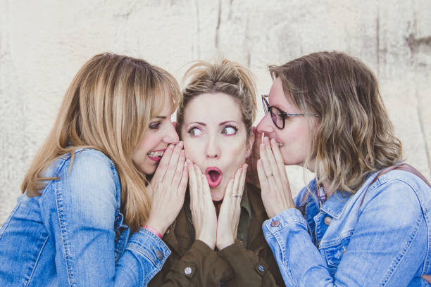 istock Three young women with winter clothing whispering secrets 1091236664