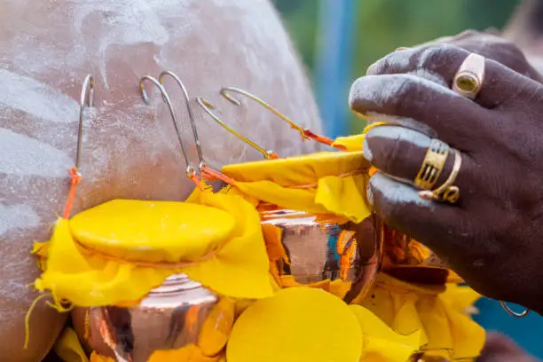 Photo of During Thaipusam festival in South East Asia, batu caves, kuala lumpur, malaysia, Hindu Devotees preparing prayer ceremony by piercing body hooks kavadi with milk pots. seeking blessing, fulfill their vows and offer thanks to the deities. Thaipusam is a c