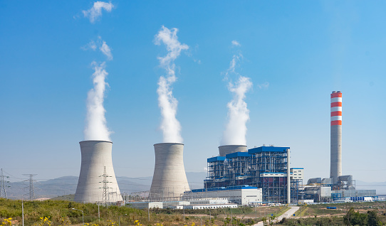 A coal-fired power station in the distance in agricultural landscape. The power station Niederaussem has the second highest cooling tower in the world