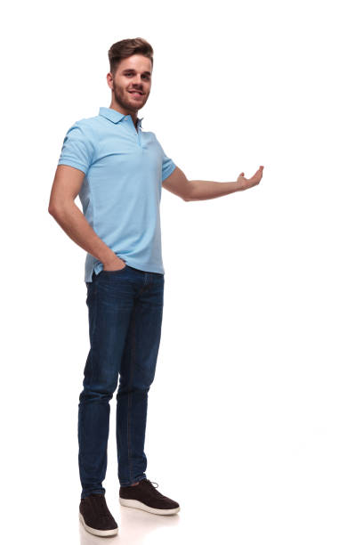 istock relaxed casual man with hand in pockets presents to side 1091244032