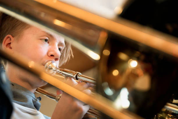Young boy playing the trombone in a band.