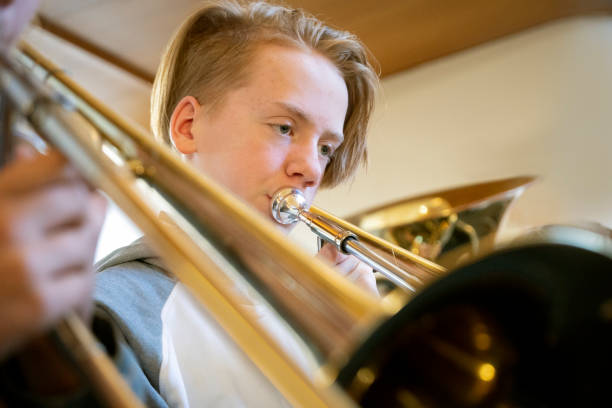 istock Young teenage boy playing the trombone 1091258194