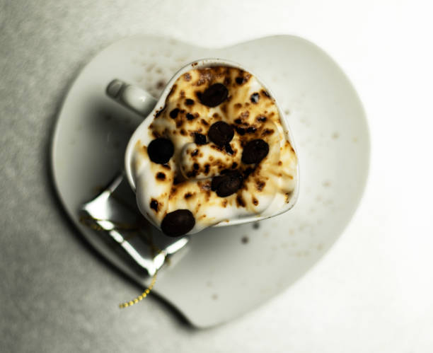 Christmas coffee with whipped cream and a small gift on ceramic saucer,