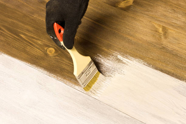 istock Human hand with brush painting wooden table 1091273338