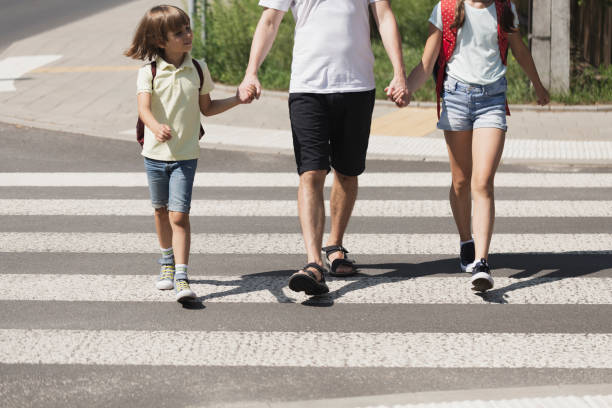 istock Parent his kids hands while crossing the street 1091286468