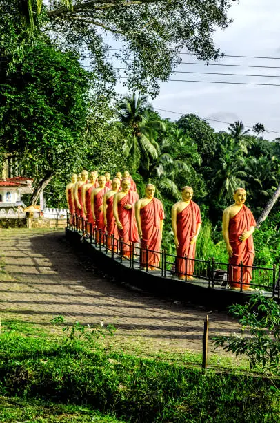 Statues of monks standing in a row, in one of the Buddhist temples of Sri Lanka.