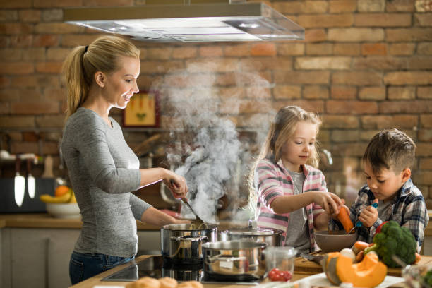 istock Happy single mother and her kids preparing lunch in the kitchen. 1091297676