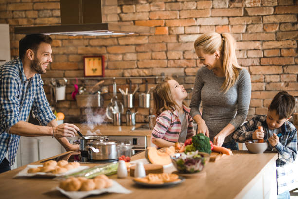 istock Young happy family communicating while preparing lunch together in the kitchen. 1091298598
