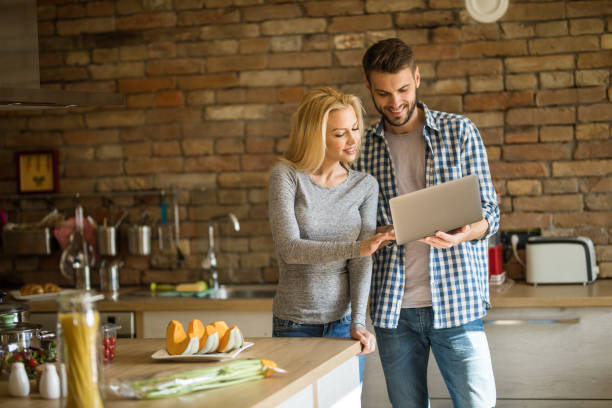 istock Happy couple reading recipes from the Internet in the kitchen. 1091299364