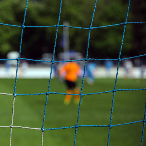 istock goalkeeper behind the net of the gate 1091301918