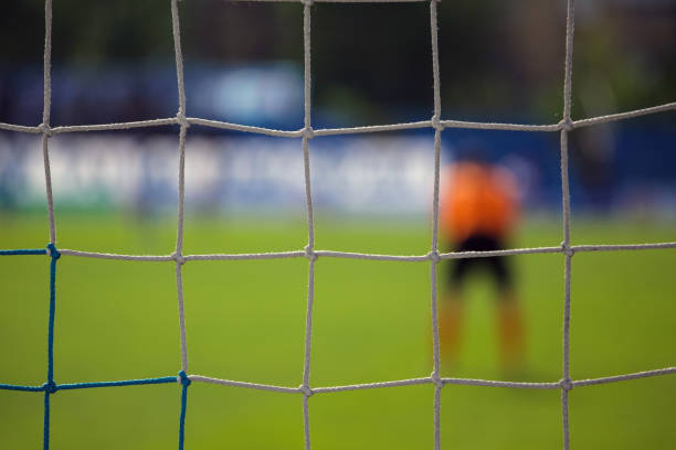 istock goalkeeper behind the net of the gate 1091301940