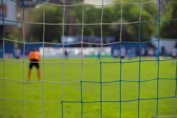 istock goalkeeper behind the net of the gate 1091301952