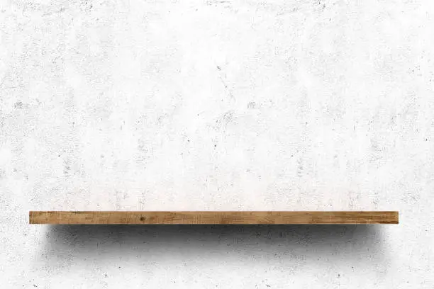 Wooden shelf over white concrete wall background