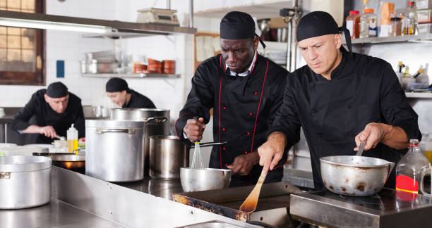 istock Positive cooks in process of working in kitchen of restaurant 1091309304