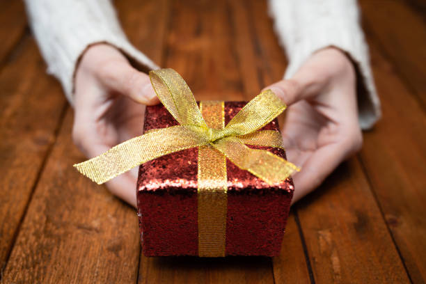 istock Women's hand with gifts 1091311098