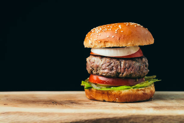 istock Delicious tasty burger on wooden table 1091316746