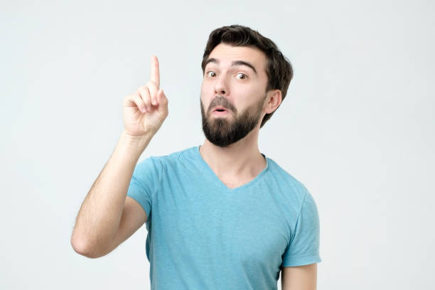 istock Experienced young man showing index fingers up, giving advice 1091322062